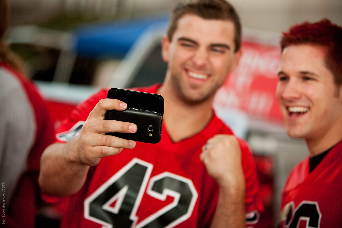 Tailgating: Guys Check Out Sports Information on Cell Phone