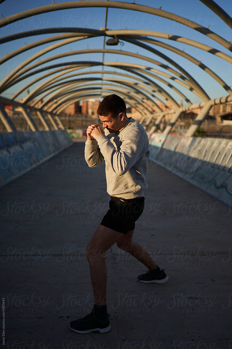 Sportsman in fighting stance on bridge