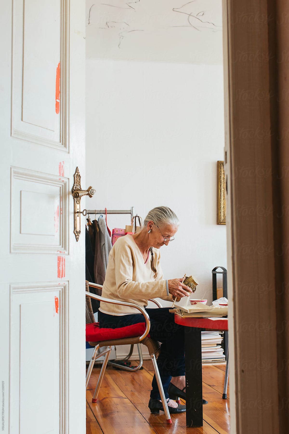 Environmental Portrait of Senior Woman with Grey Hair Making Natural Incense
