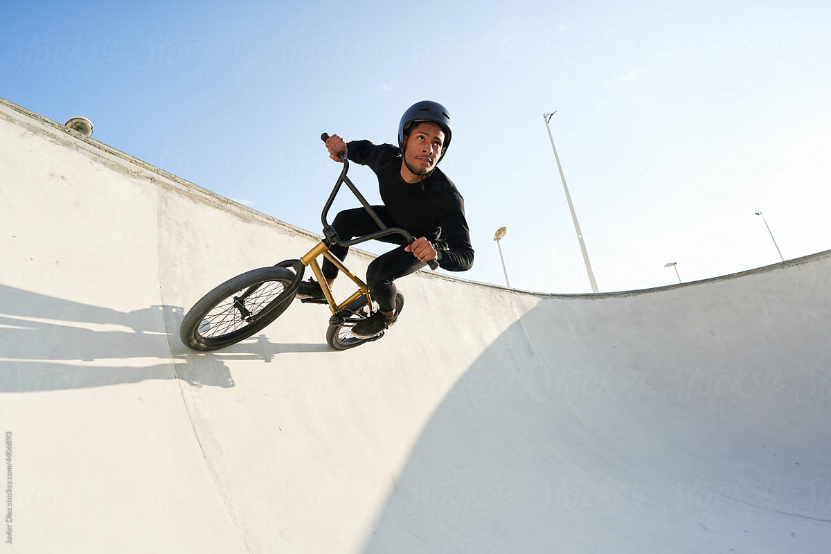Young man riding bicycle in skate park