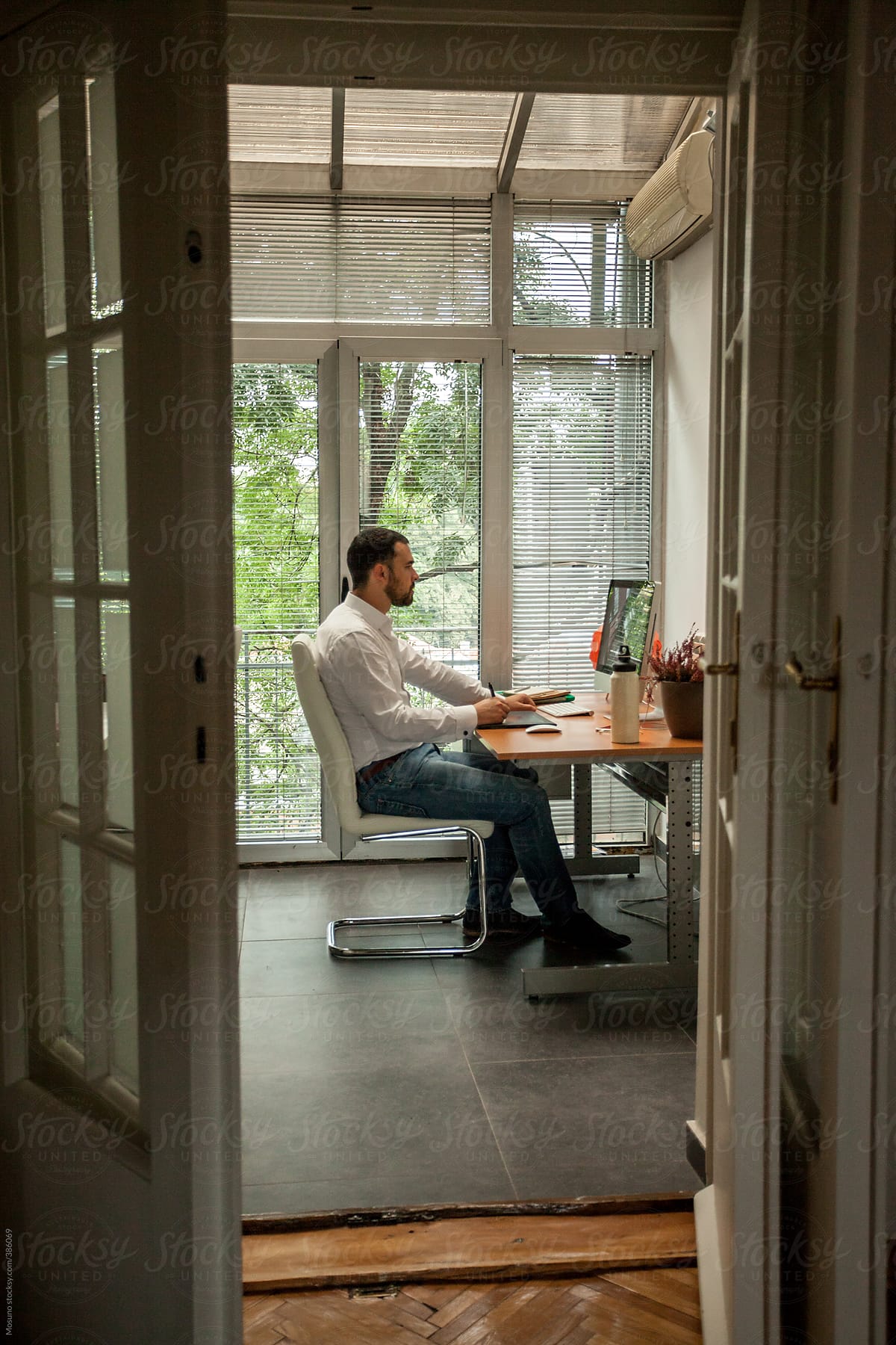 "Man Working In His Home Office" by Stocksy Contributor "Mosuno" - Stocksy