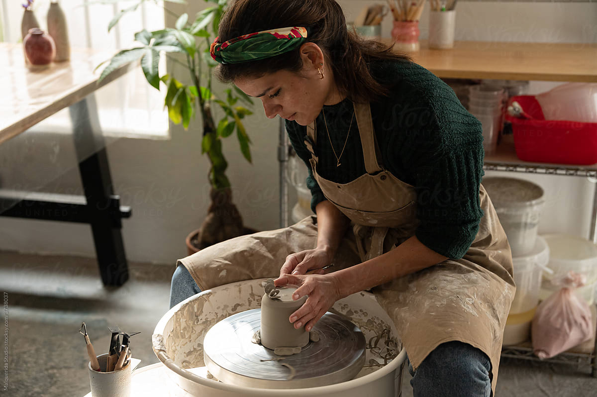 Ceramist working clay With Pottery lathe in her workshop