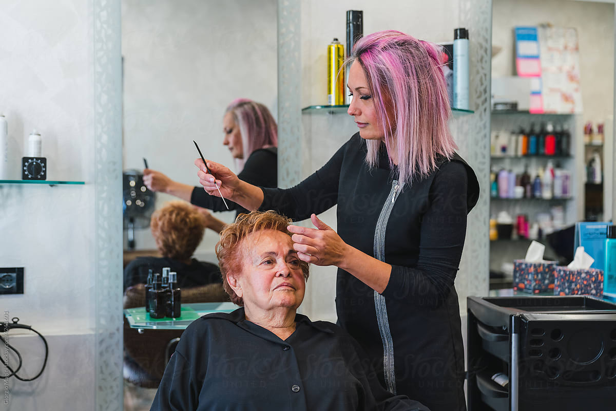 Hairdresser Combing a Senior Client in the Salon