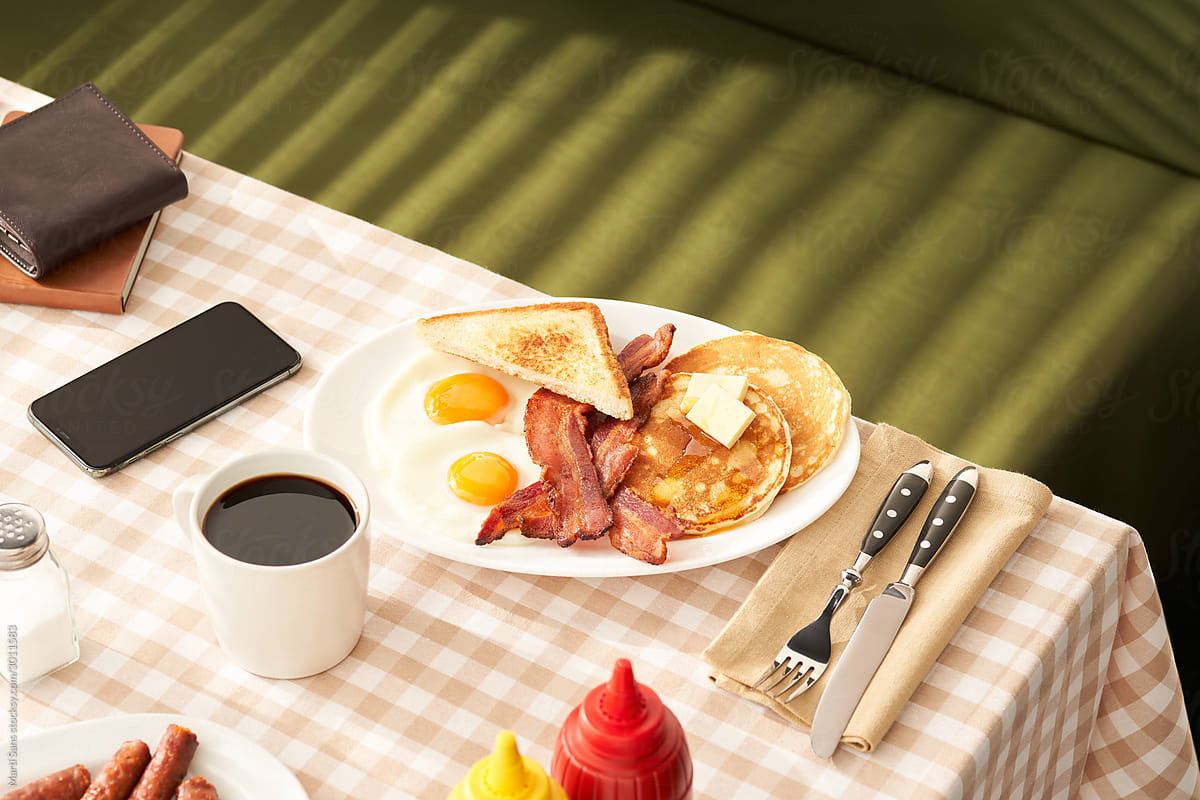 Tasty breakfast on table with smartphone and wallet