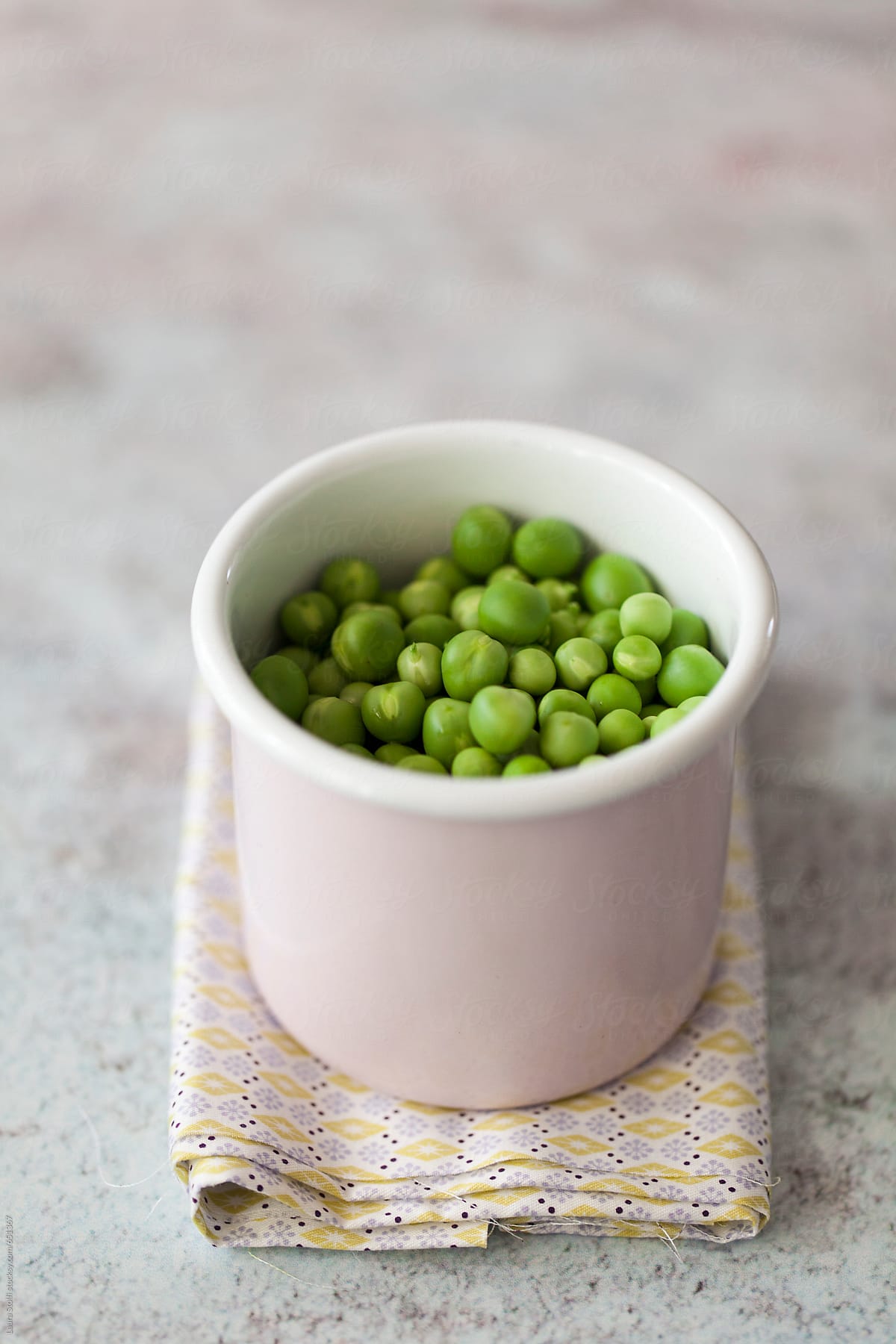 Close up of fresh green peas in pink enamel cup