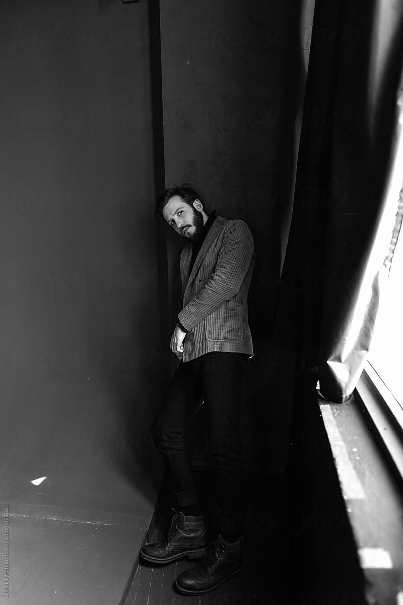 Male model leans against wall in studio