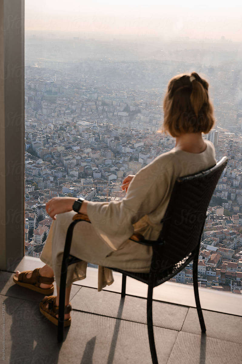 Unrecognizable woman admiring city from viewpoint