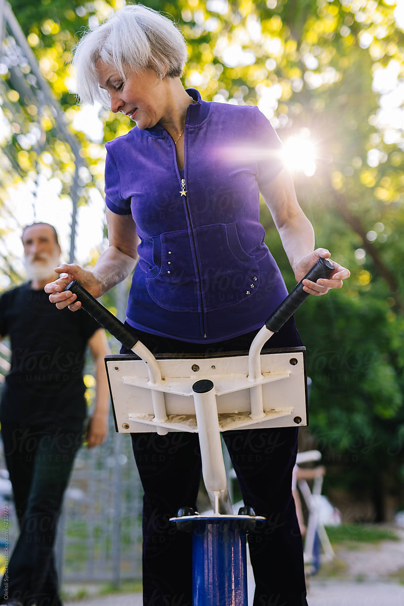 Old woman training on elliptical trainer