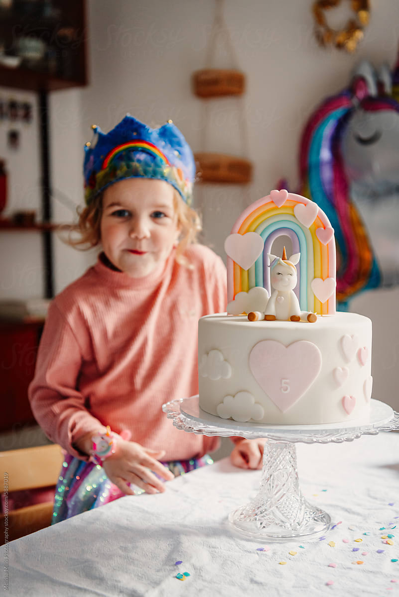 Girl turning five with her unicorn and pastel rainbow themes bday cake