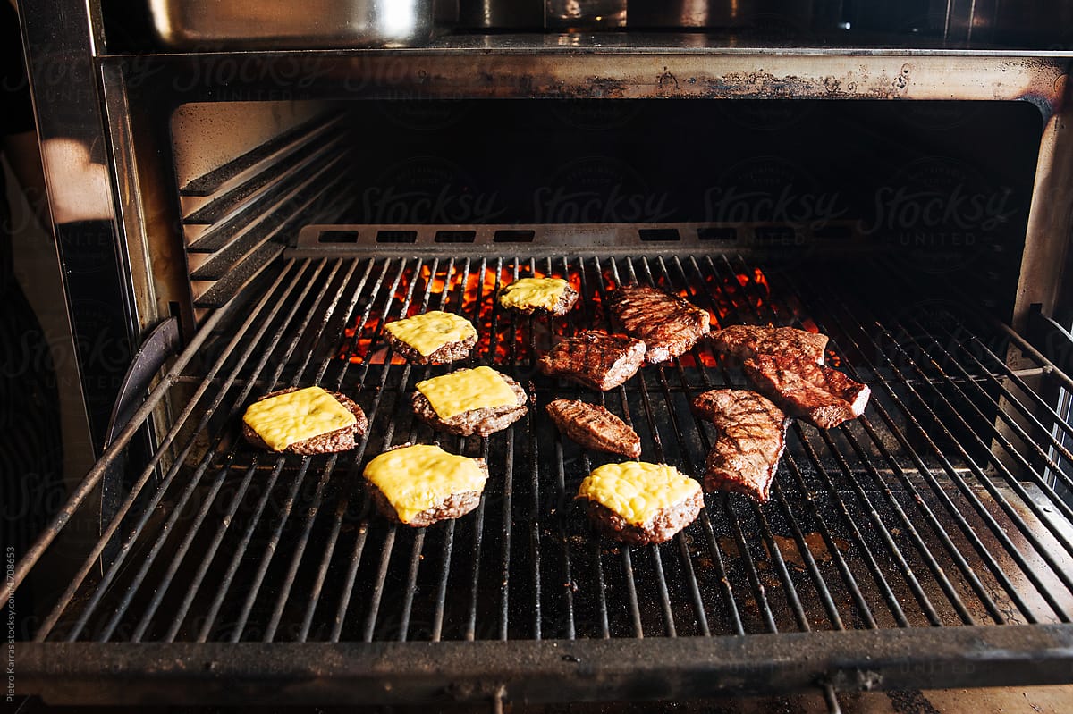 Meat and vegetables cooking on grill, at professional cafe kitchen
