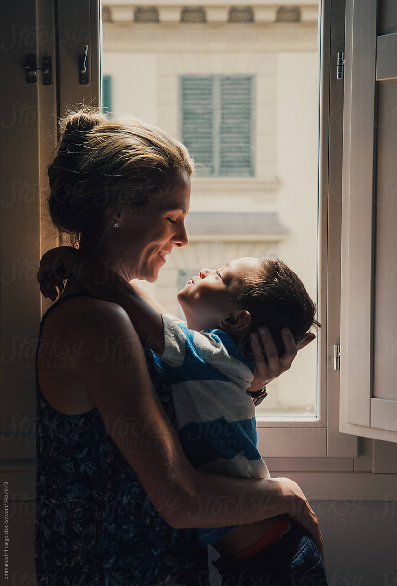Mother and son playing by the window in their room