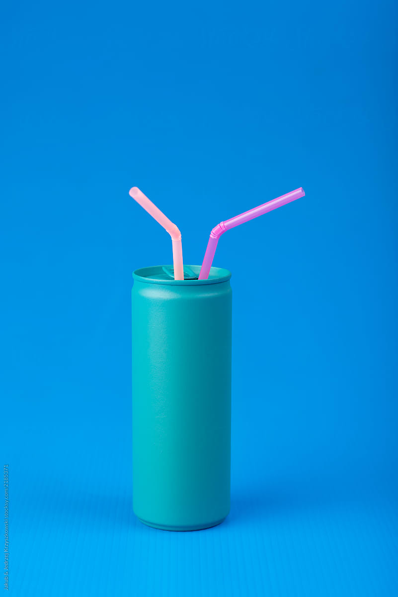 Turquoise can with pink straws on blue background