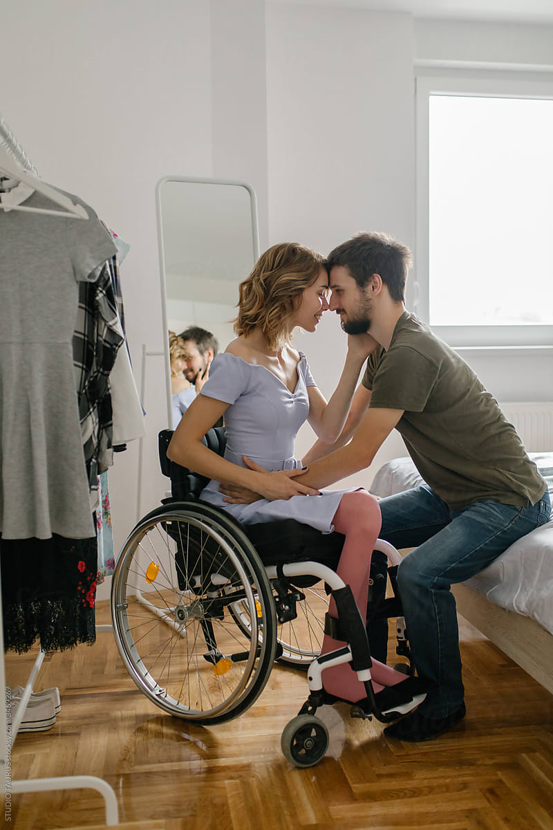 Young woman in a wheelchair changing her clothes