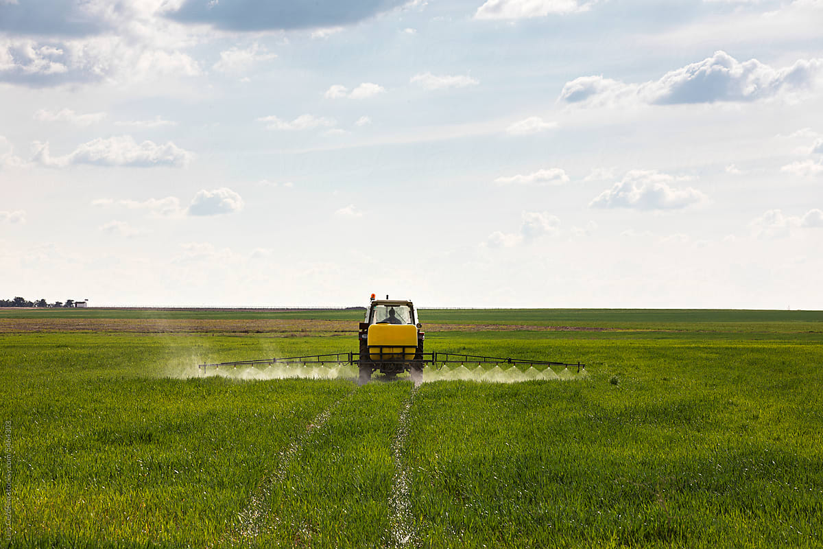 Tractor spraying chemicals to crops