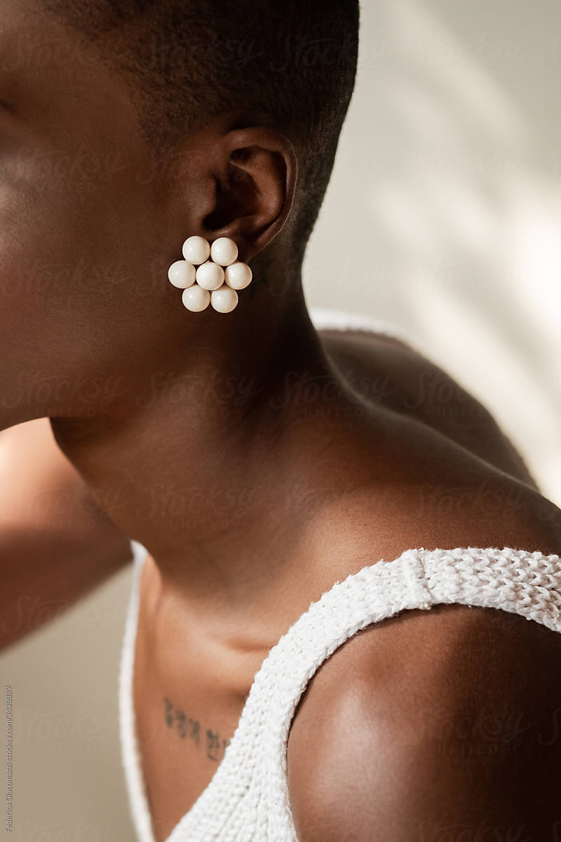 Black Woman Shoulder Detail With Korean Tattoo and Gold Earring