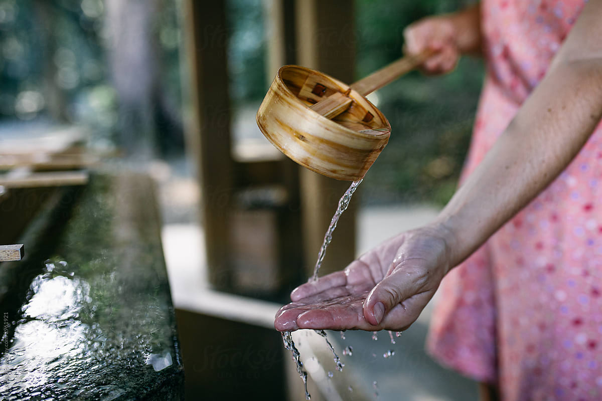 Crop woman washing hands in fountain