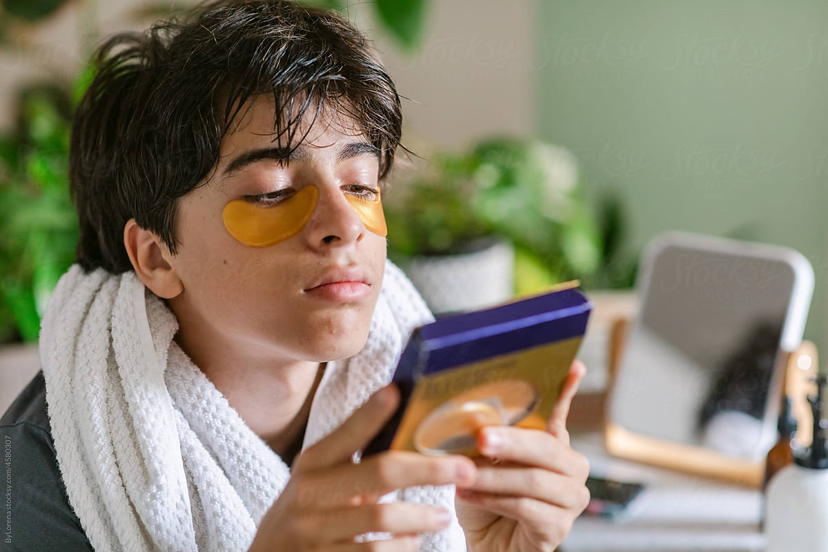 Teen boy reading instructions under-eyes mask