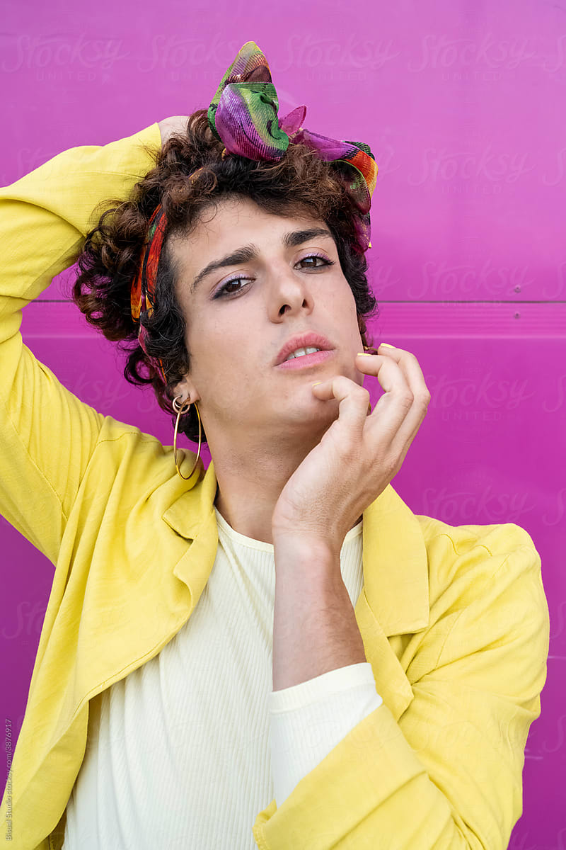 Portrait of young transgender woman on pink background