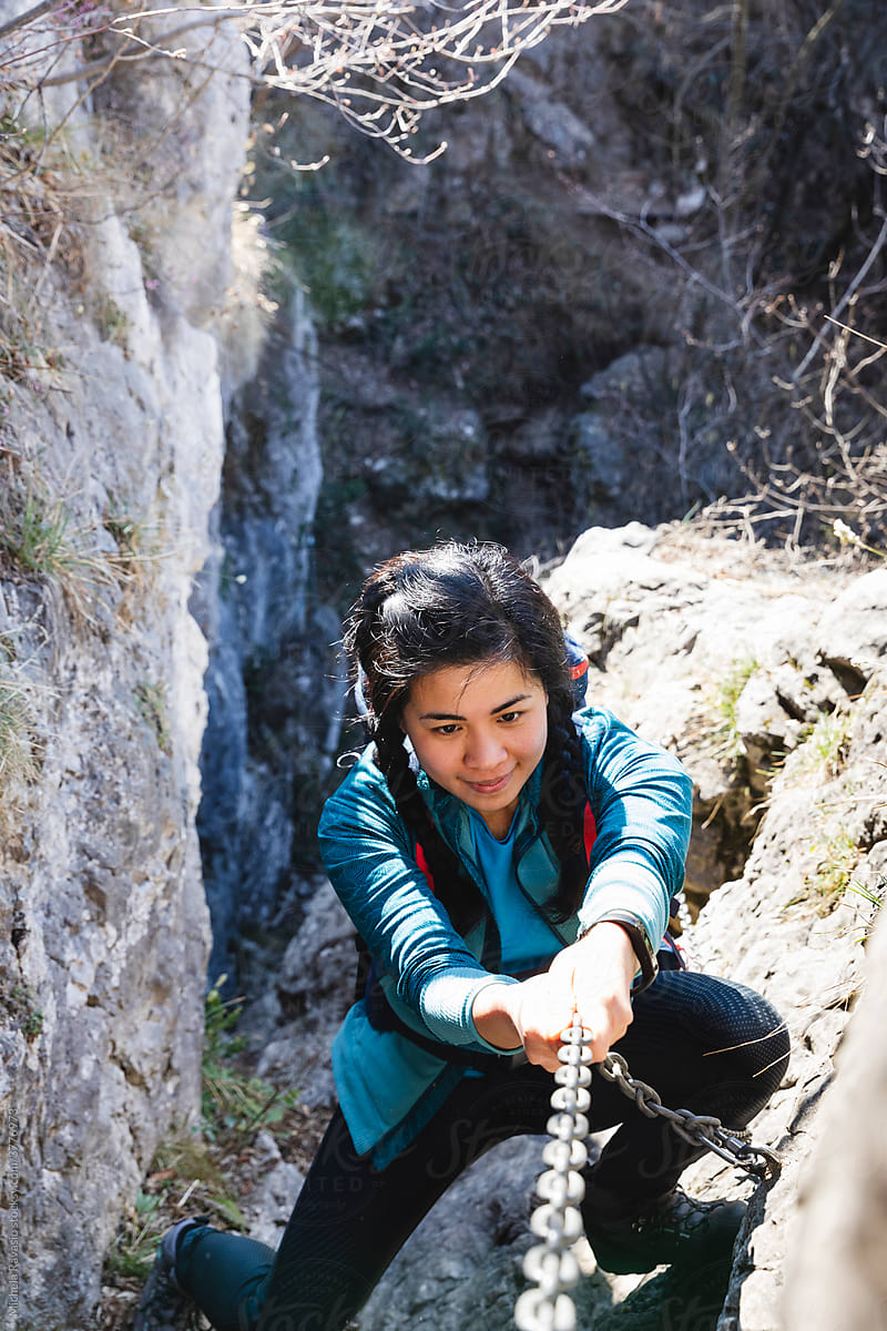 Woman concentrated in climbing on the rocks