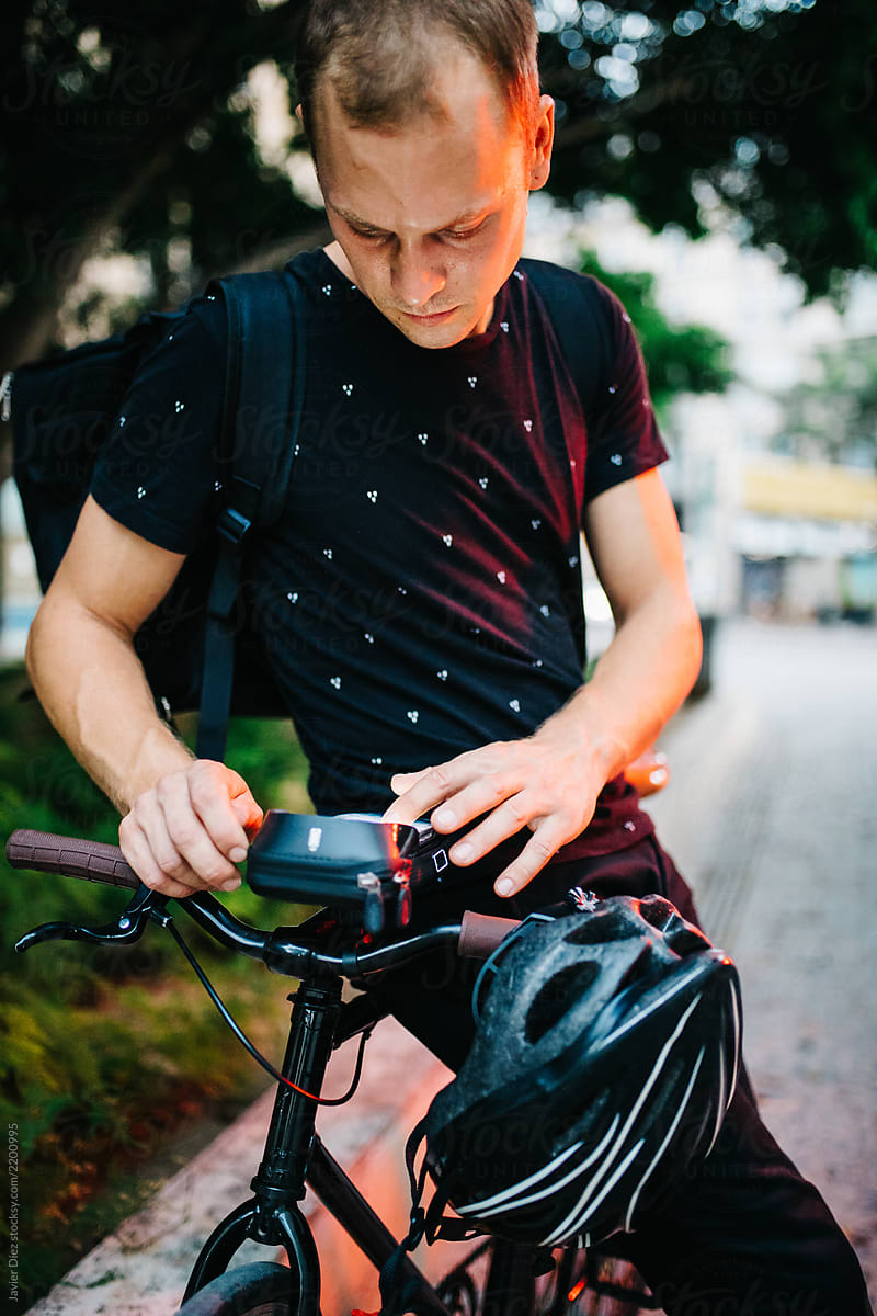 Casual man using smartphone on bicycle