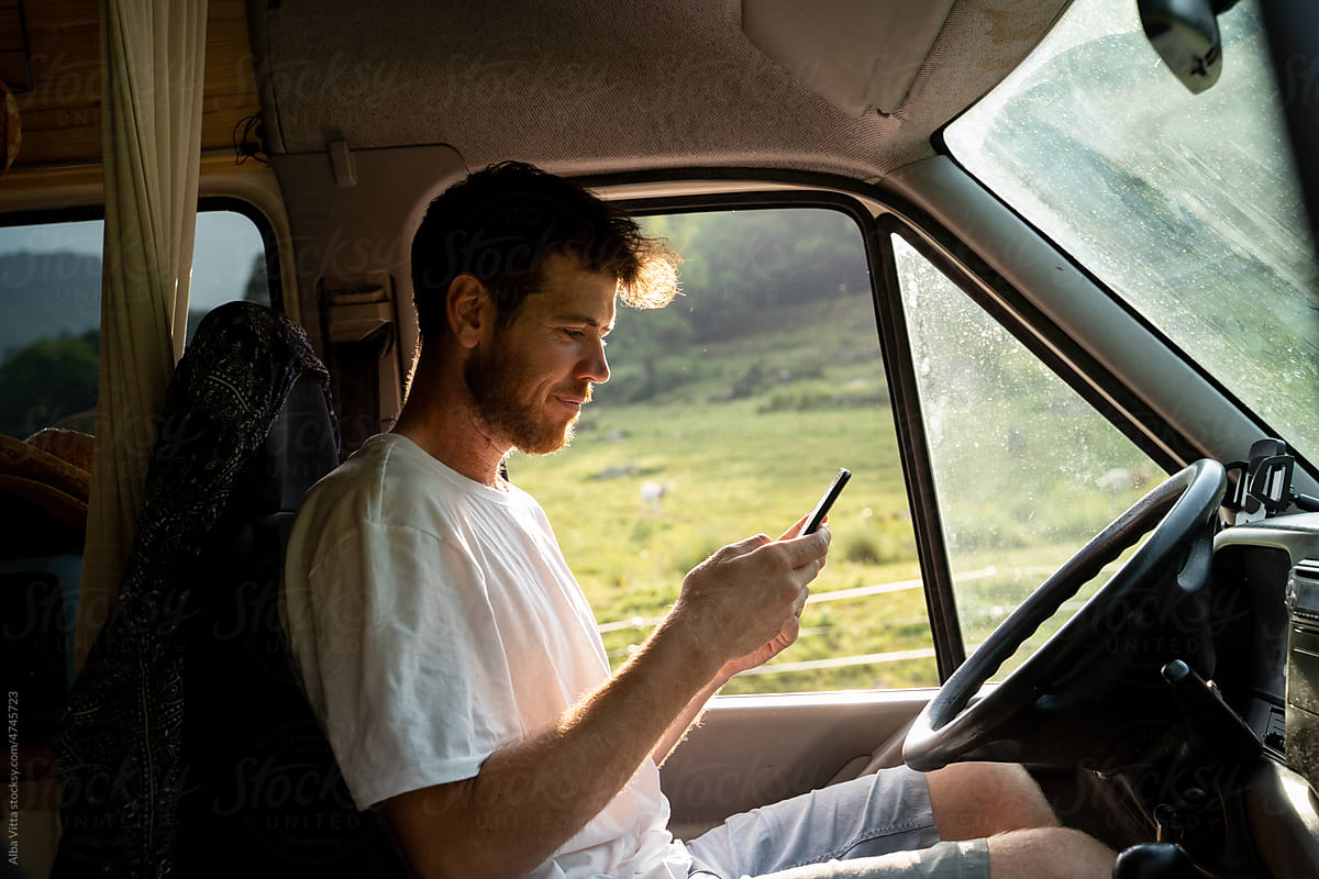 Man using phone inside camper van