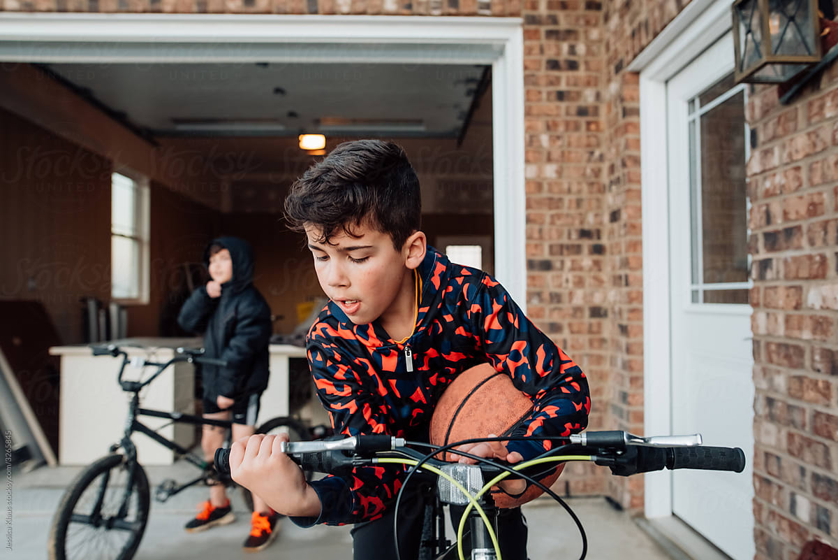 Boy adjusting handles on bike.