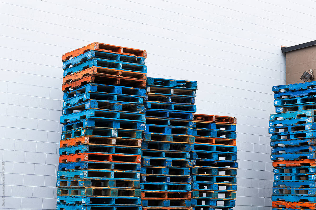 A pile of colored pallet in front of a white wall