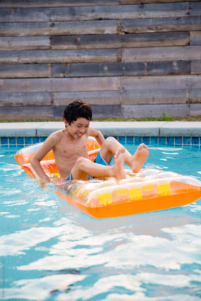 Young boy smiling and laughing in pool