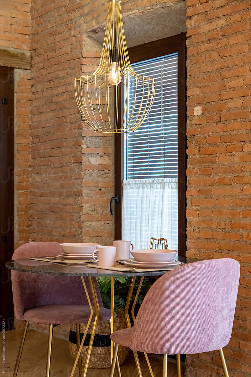 Table with dishware in kitchen with brick walls