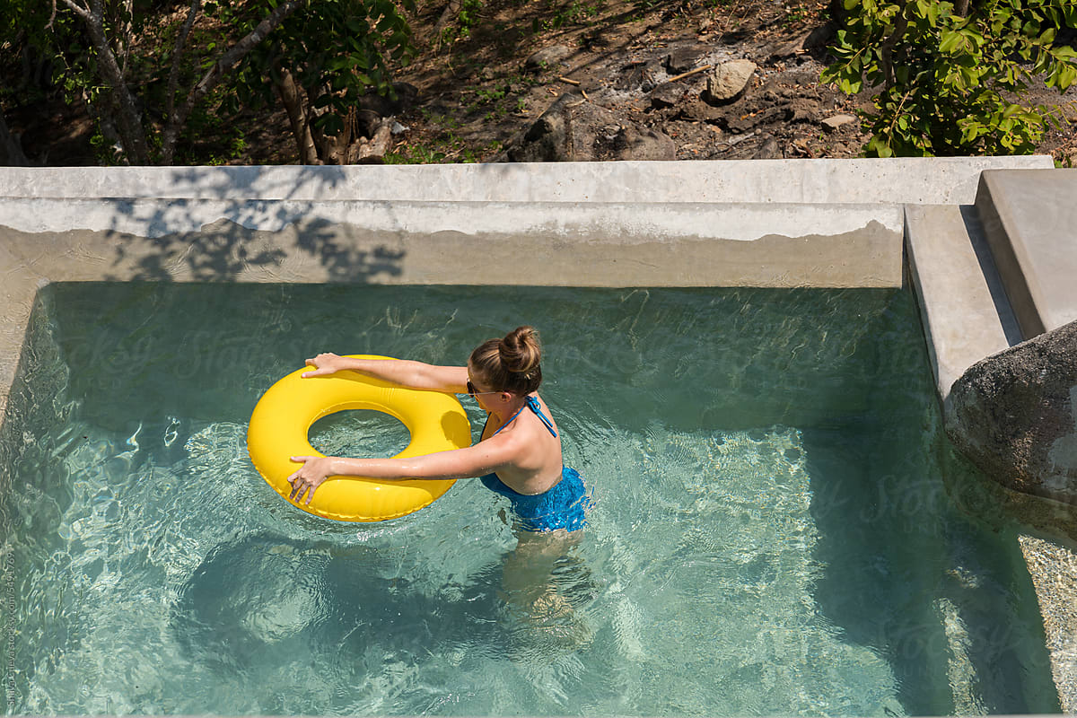 A blonde woman in a blue bikini on a pool