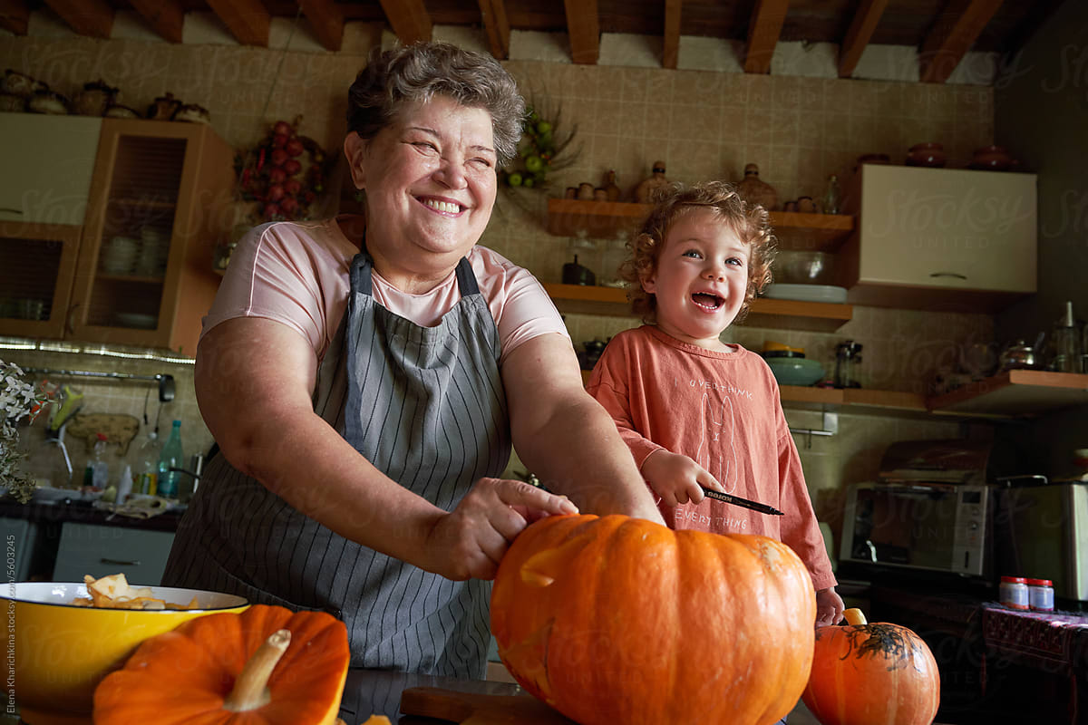 Grandmother and granddaughter carve a pumpkin for the holiday