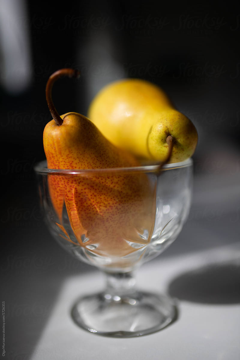 two yellow  pears in the glass vase