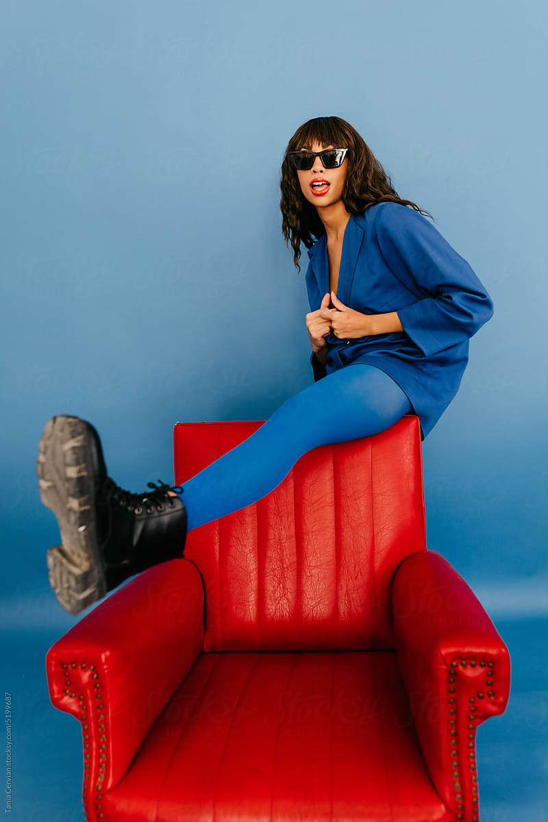 Woman in sunglasses putting leg on armchair