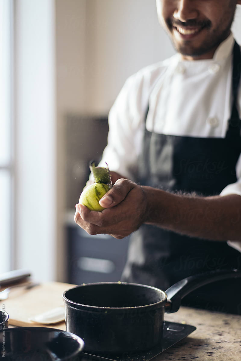 Pastry chef peeling a lemon
