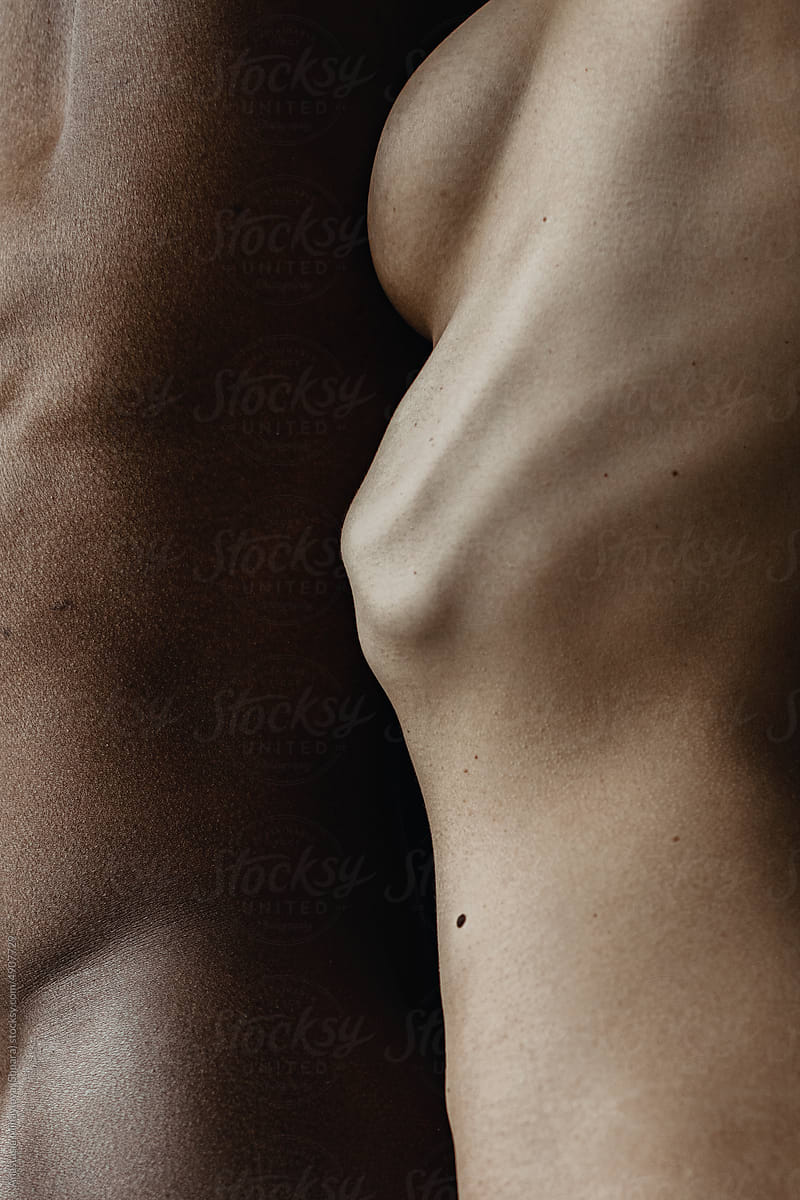 Close up skin texture of white woman and black man standing together