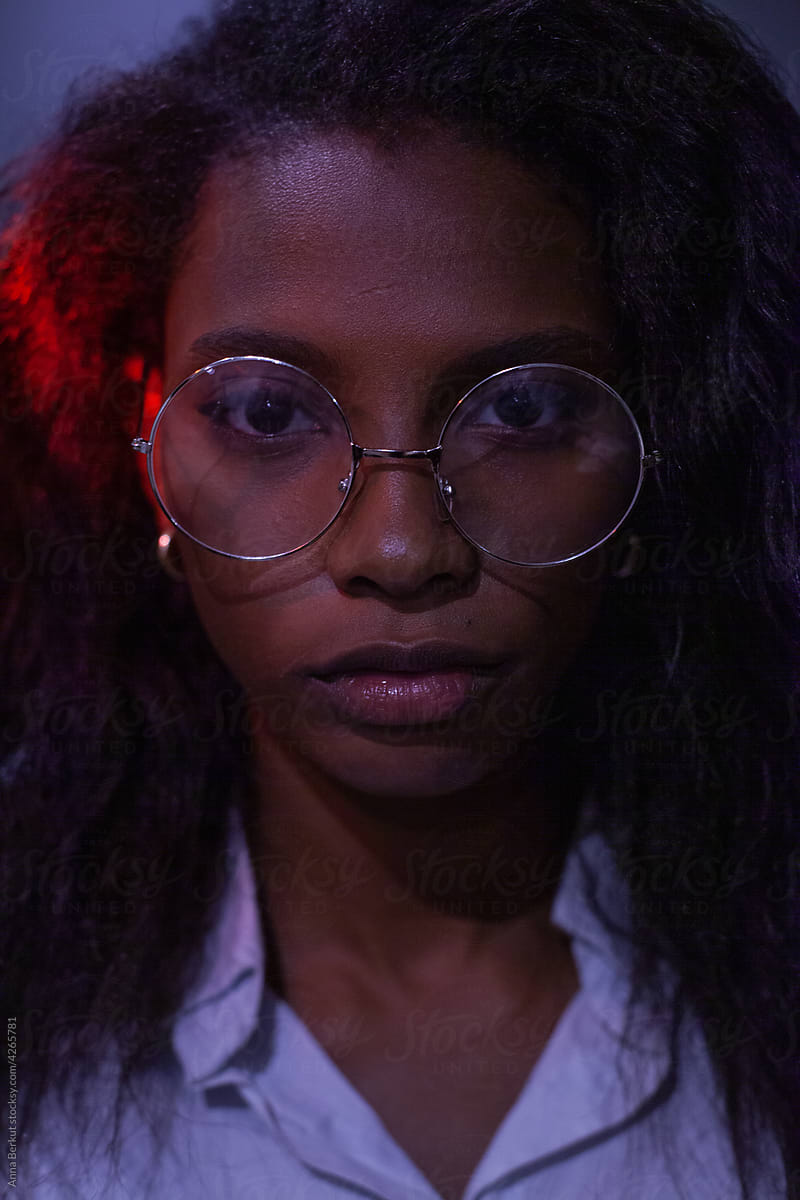 serious young woman wearing glasses looking at camera portrait