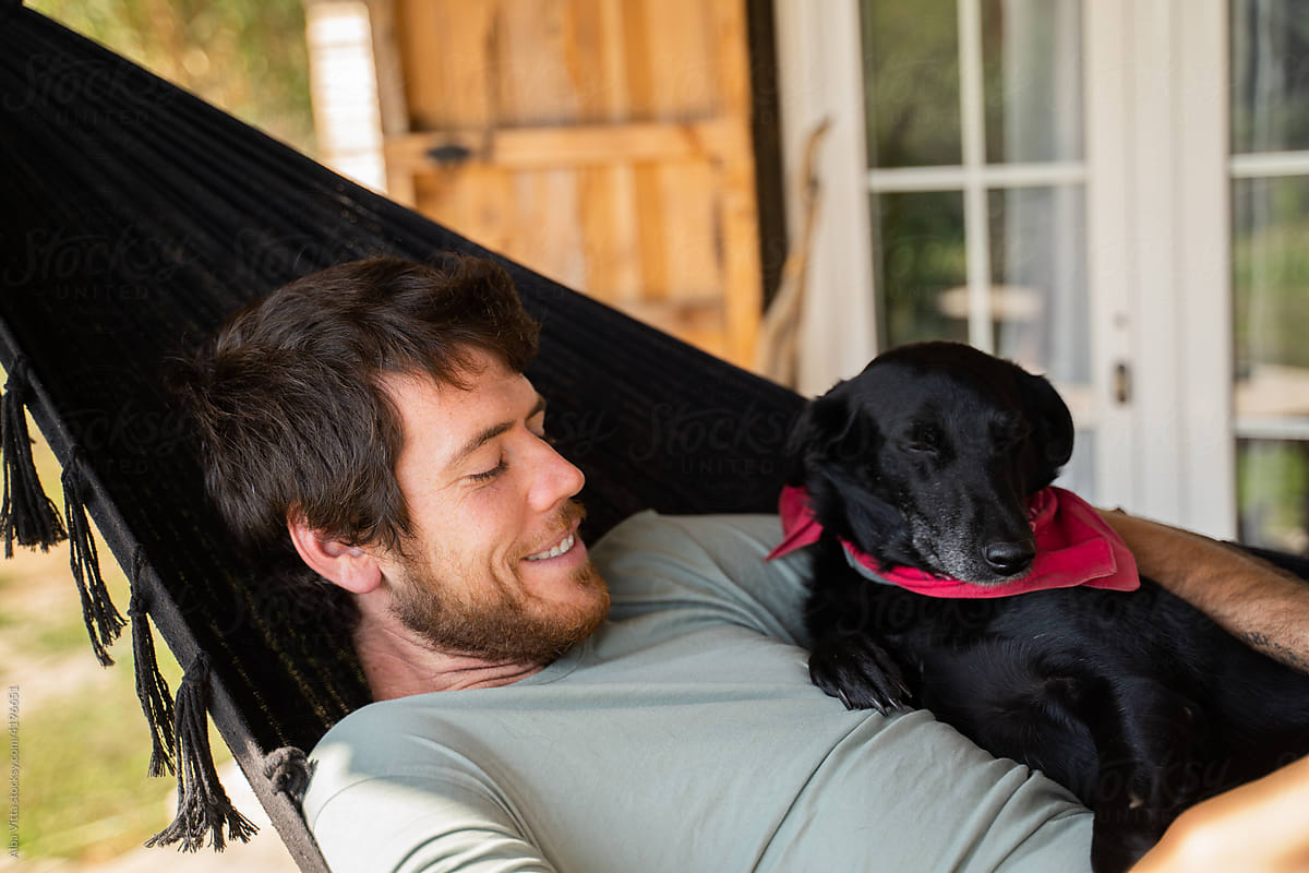 Young Man with dog relaxing in hammock
