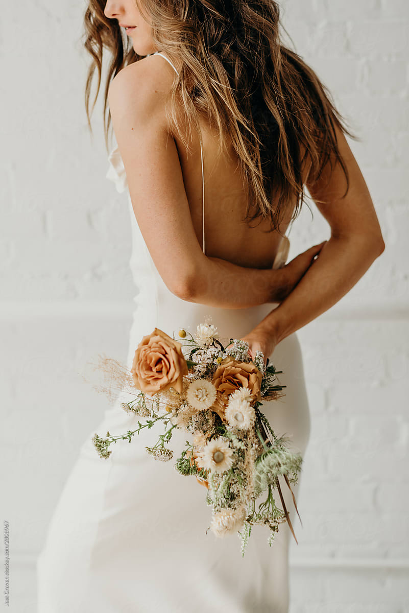 Young bride holding dried flower bouquet