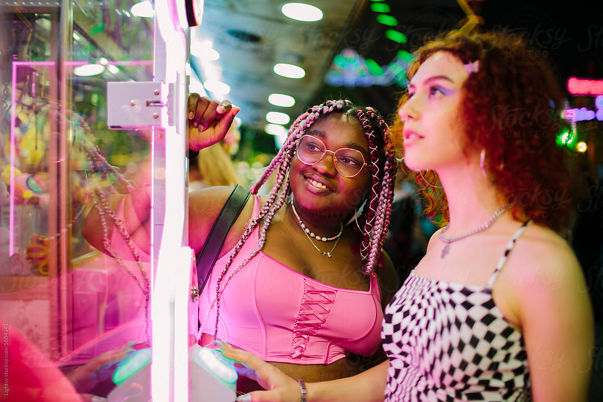 Portrait of two young women playing at a fair at night