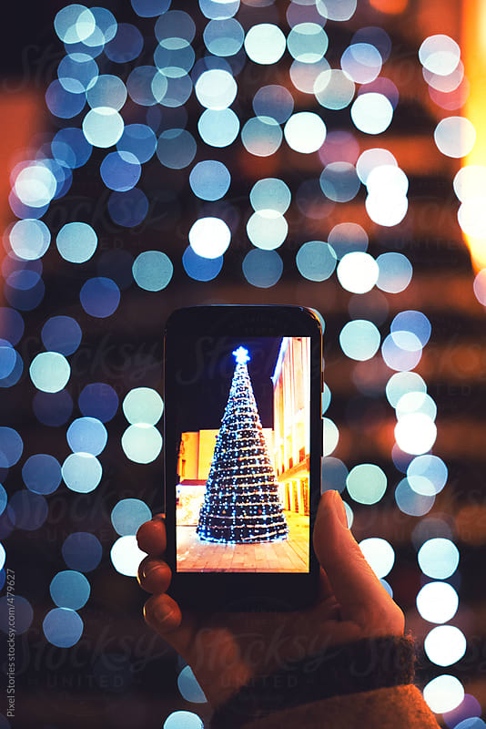 Woman taking picture of Christmas tree decorated