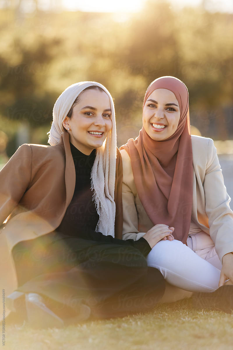 Happy Muslim women in hijab hugging and caressing a friend