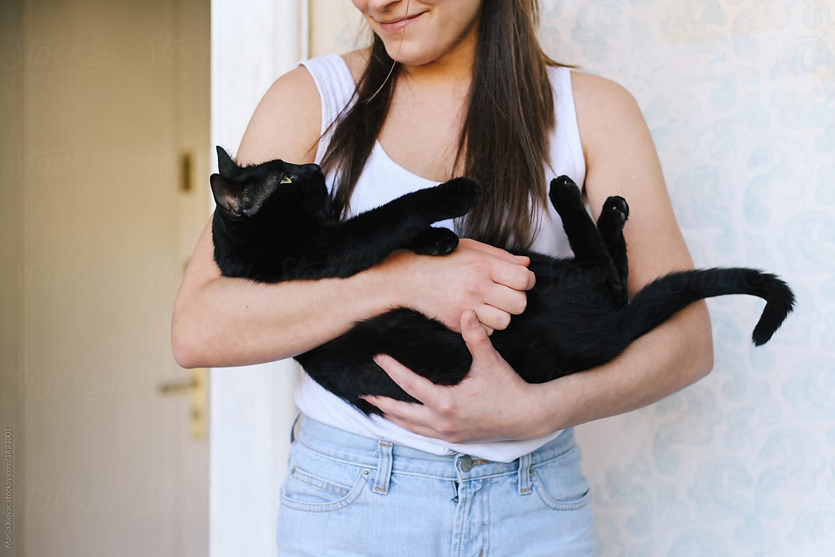 Woman holding her black cat