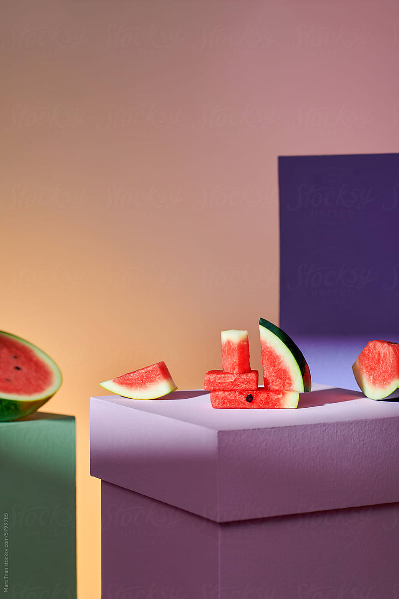 Ripe watermelon slices on colorful cube podiums