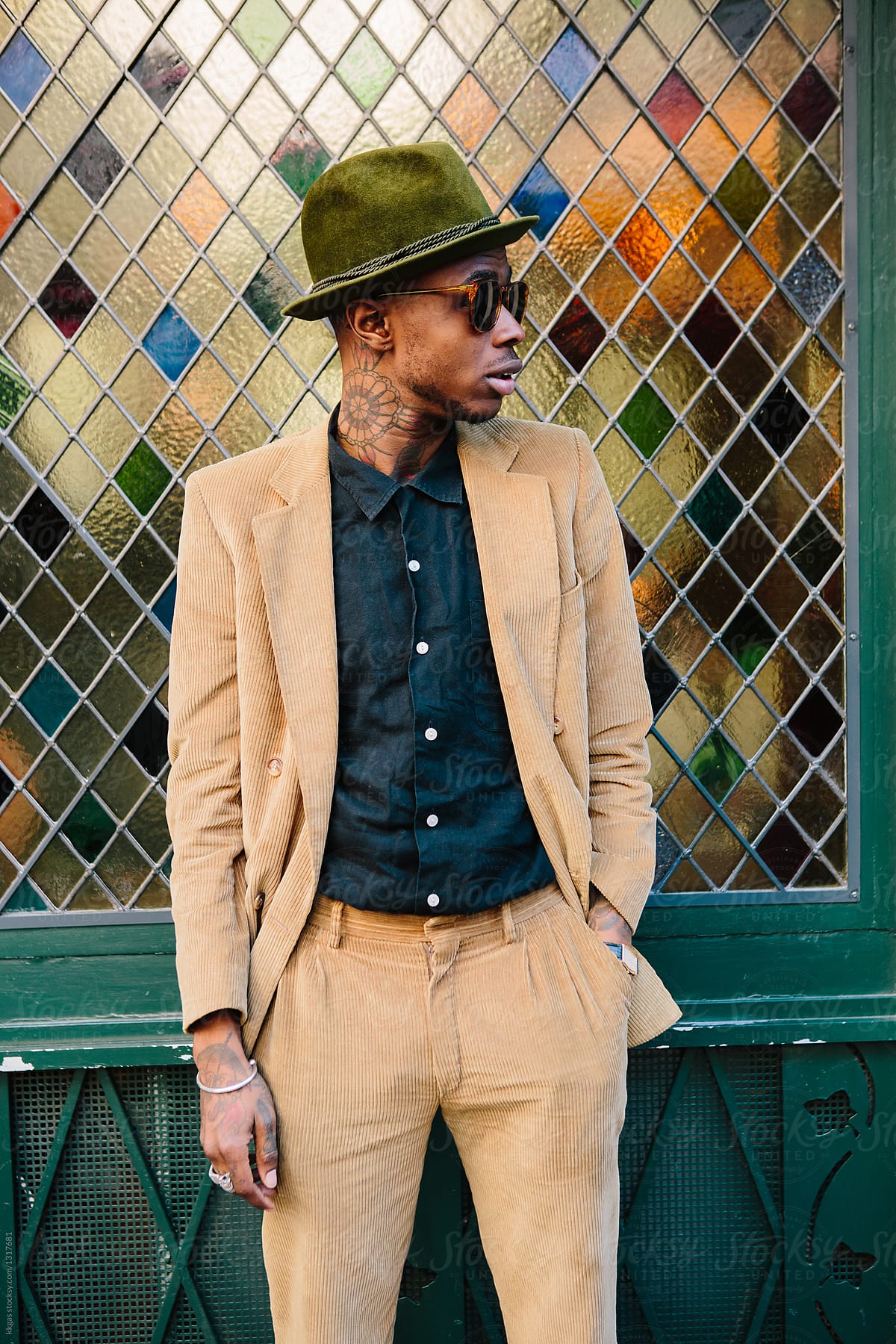 Stylish young black man with tattoos and hat