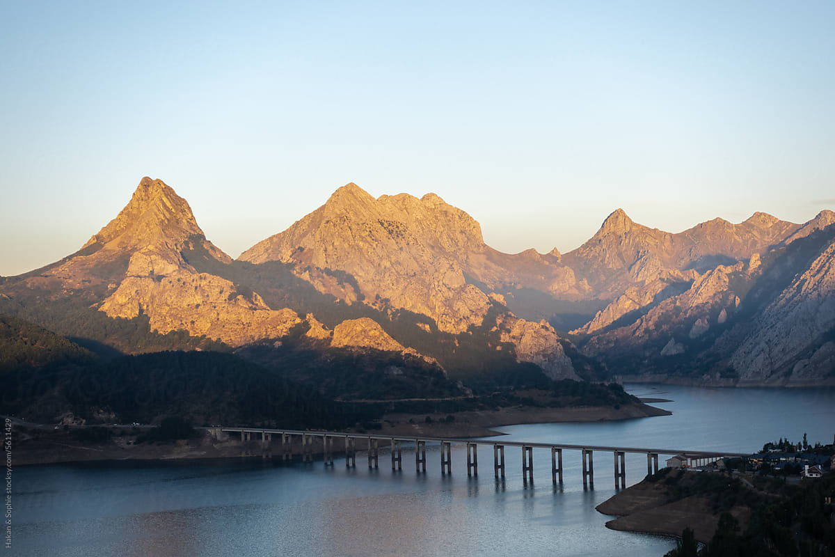Lake, bridge, mountains bathed in the first light of day