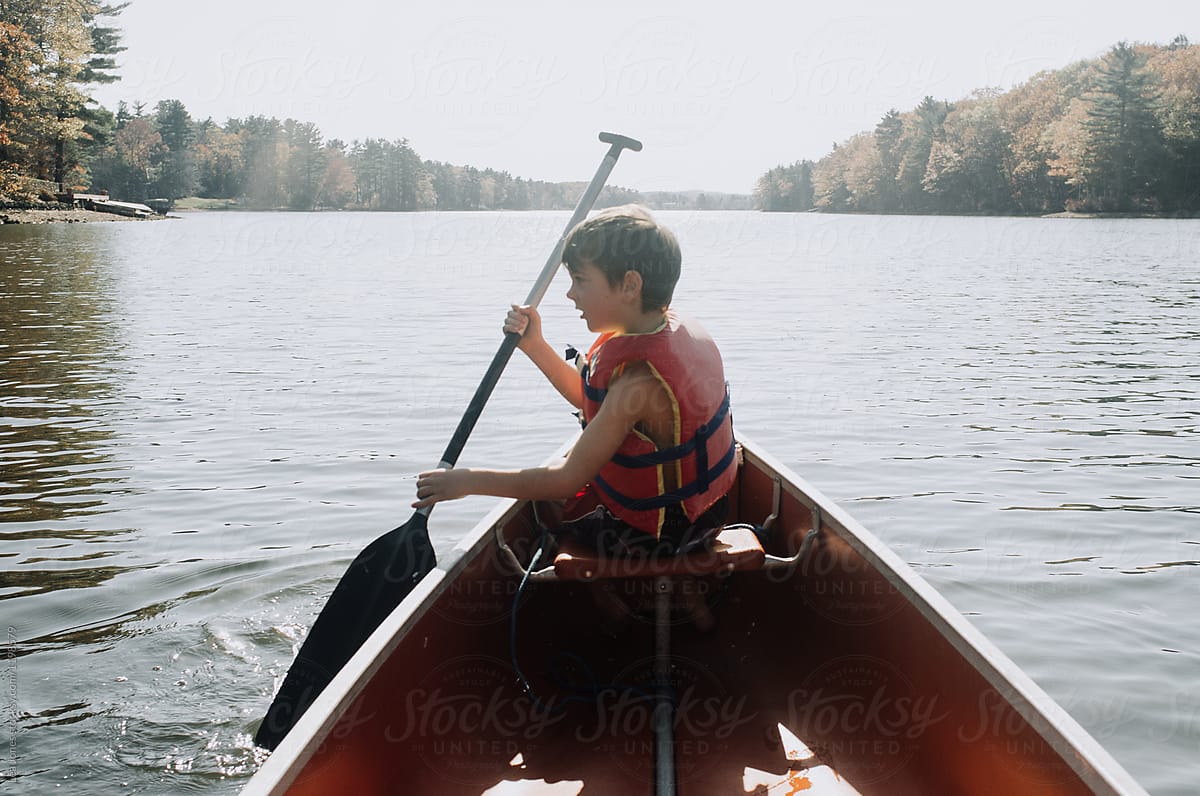 stock photo of boy rowing in a canoe