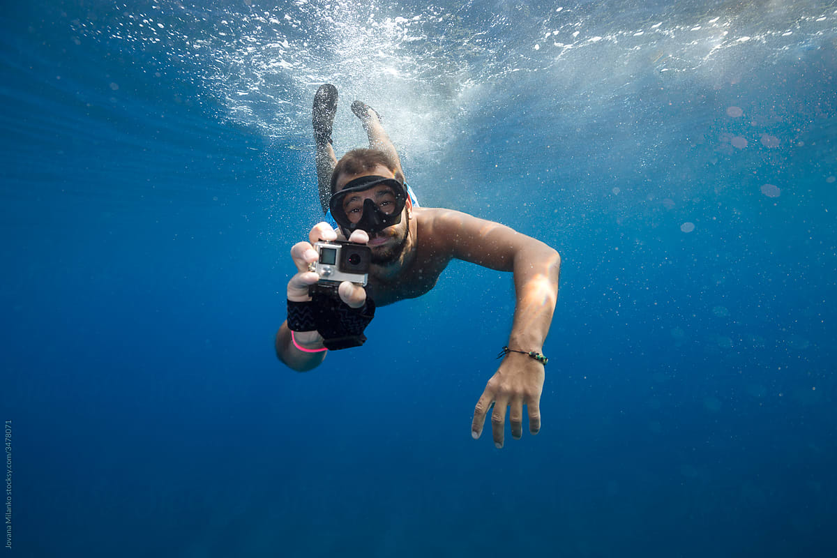Man filming with action cam underwater