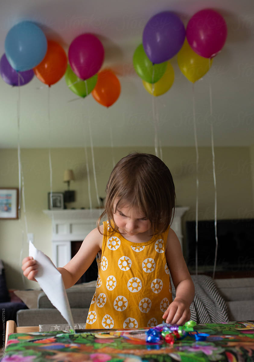Little Girl Unwraps her Presents at her Birthday Party