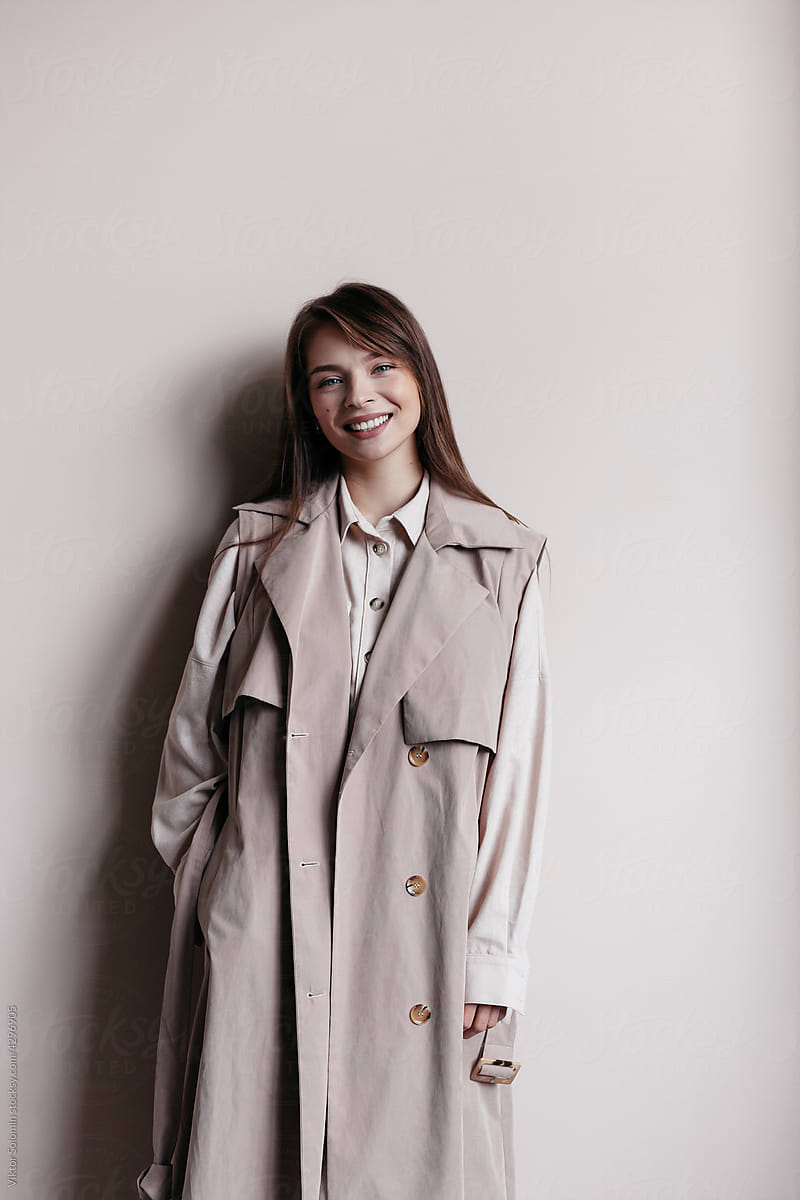 Smiling woman in stylish beige trench