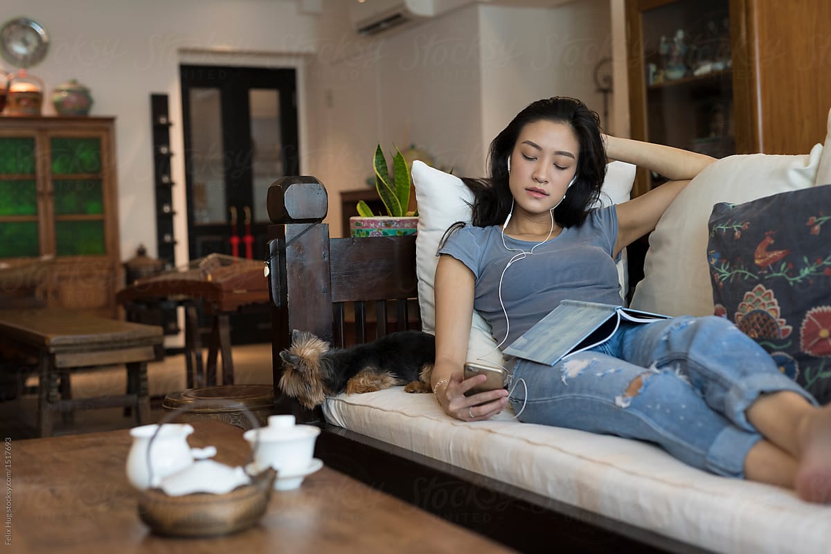Singaporean woman on her sofa looking at the phone
